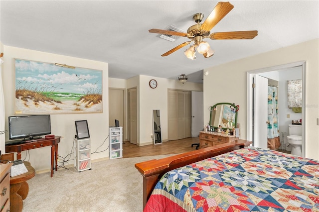 800 Jefferis Ct, Eustis, FL 32726 - carpeted bedroom featuring two closets, ensuite bathroom, baseboards, and ceiling fan