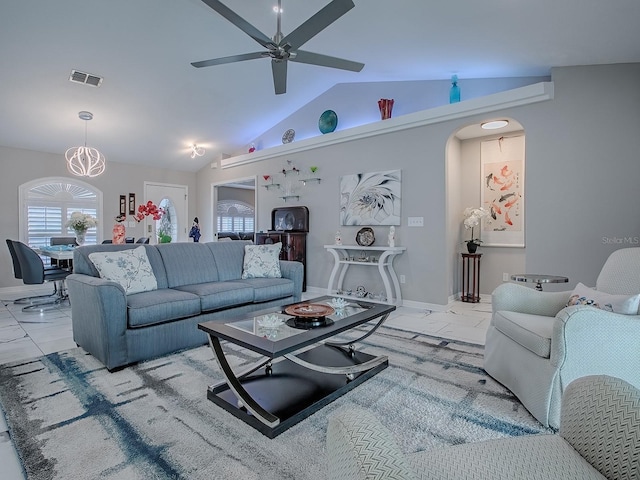 living area featuring vaulted ceiling, ceiling fan, arched walkways, and baseboards