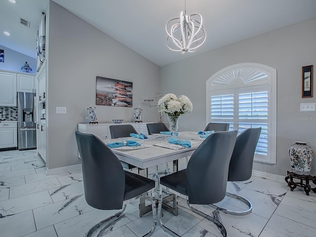 dining space with vaulted ceiling, a chandelier, light marble finish floors, baseboards, and plenty of natural light