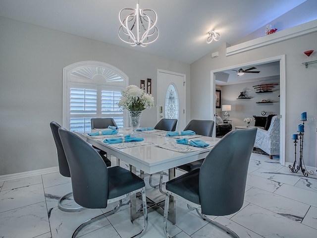 dining space with light marble finish floors, a chandelier, lofted ceiling, baseboards, and a ceiling fan