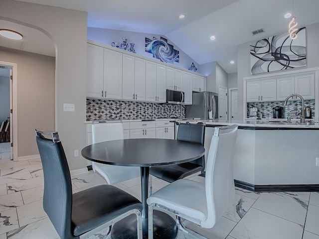 dining area with light marble finish floors, lofted ceiling, arched walkways, baseboards, and recessed lighting