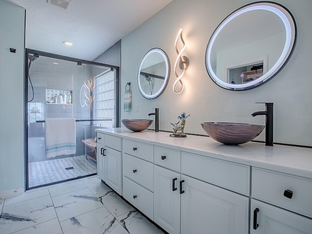 bathroom with a tile shower, marble look tiles, double vanity, and recessed lighting