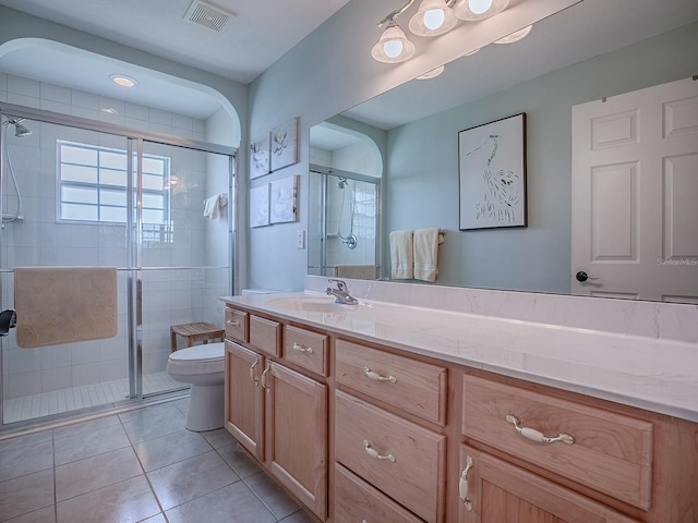 bathroom with toilet, a stall shower, tile patterned floors, and vanity