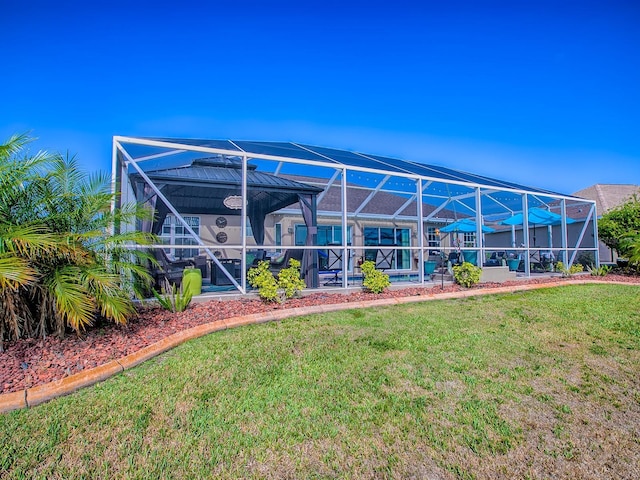 rear view of property featuring a lawn, a lanai, an outdoor pool, and a patio