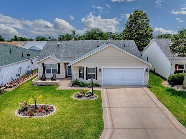 view of front of home featuring central air condition unit, an attached garage, a front yard, and driveway