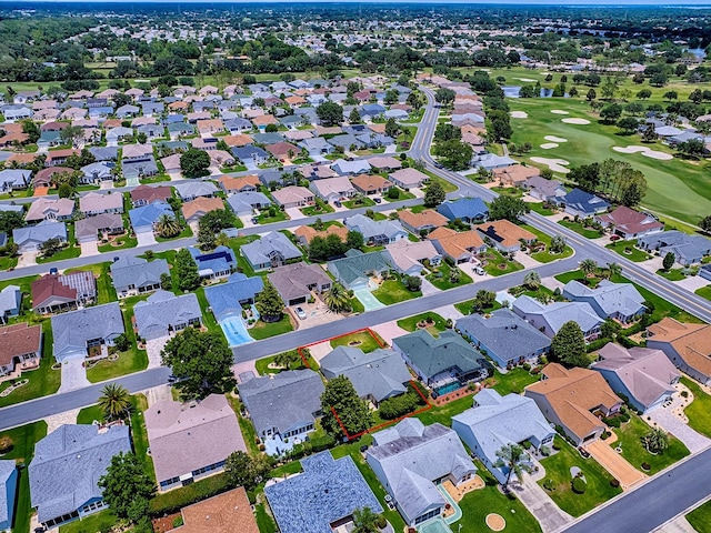 view of property location featuring a golf club and nearby suburban area