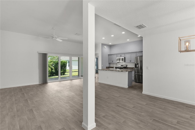 3745 Causey Ct, The Villages, FL 32163 - unfurnished living room featuring a ceiling fan, light wood-style floors, a sink, baseboards, and recessed lighting