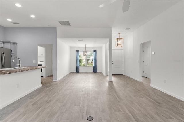 3745 Causey Ct, The Villages, FL 32163 - unfurnished living room with a sink, a chandelier, ceiling fan, light wood-type flooring, and recessed lighting