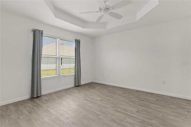 3745 Causey Ct, The Villages, FL 32163 - spare room with a tray ceiling, light wood finished floors, a ceiling fan, and baseboards