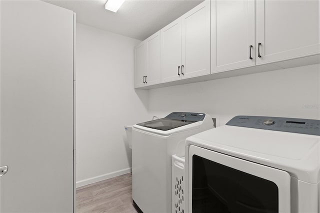 3745 Causey Ct, The Villages, FL 32163 - laundry area featuring separate washer and dryer, cabinet space, light wood-style flooring, and baseboards