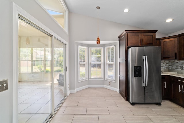6259 SE 120th Pl, Belleview, FL 34420 - kitchen featuring stainless steel refrigerator with ice dispenser, lofted ceiling, dark brown cabinetry, decorative backsplash, and light countertops
