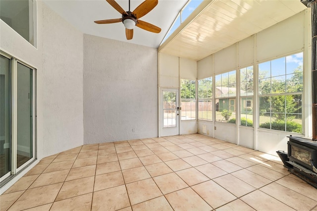 6259 SE 120th Pl, Belleview, FL 34420 - unfurnished sunroom featuring ceiling fan, a textured wall, a wood stove, and tile patterned flooring