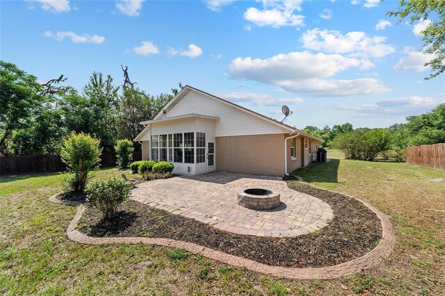 6259 SE 120th Pl, Belleview, FL 34420 - back of property featuring a patio area, a fire pit, and a sunroom