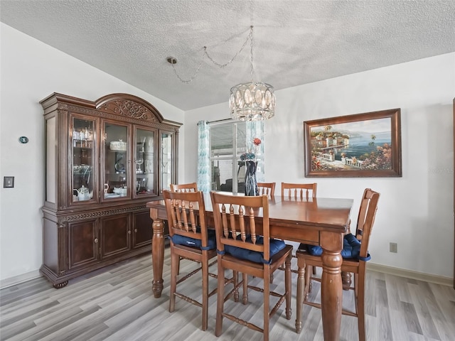 1202 Del Toro Dr, Lady Lake, FL 32159 - dining room featuring a chandelier, light wood-style flooring, and a textured ceiling