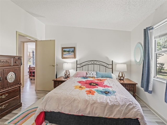 1202 Del Toro Dr, Lady Lake, FL 32159 - bedroom with light wood-style floors, a textured ceiling, and lofted ceiling