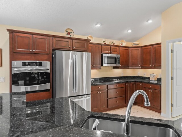 1642 Pennecamp Dr, The Villages, FL 32162 - kitchen featuring appliances with stainless steel finishes, a sink, dark stone counters, vaulted ceiling, and recessed lighting