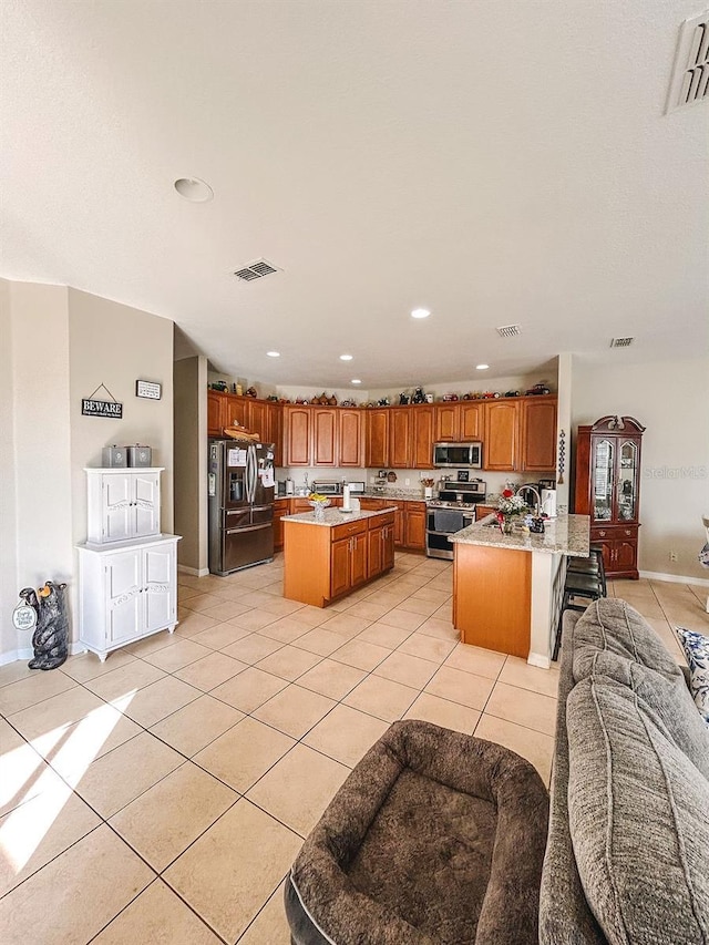 33818 Venice Ln, Sorrento, FL 32776 - kitchen featuring stainless steel appliances, open floor plan, light tile patterned flooring, brown cabinetry, and recessed lighting