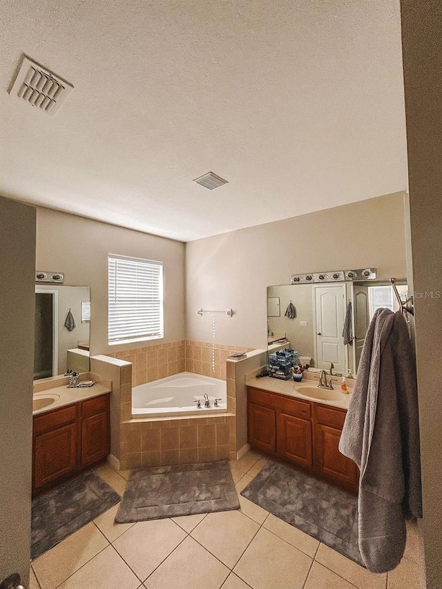 33818 Venice Ln, Sorrento, FL 32776 - full bath featuring a bath, two vanities, tile patterned flooring, and a textured ceiling