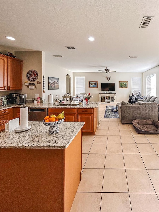33818 Venice Ln, Sorrento, FL 32776 - kitchen with open floor plan, black dishwasher, brown cabinetry, ceiling fan, and light tile patterned floors