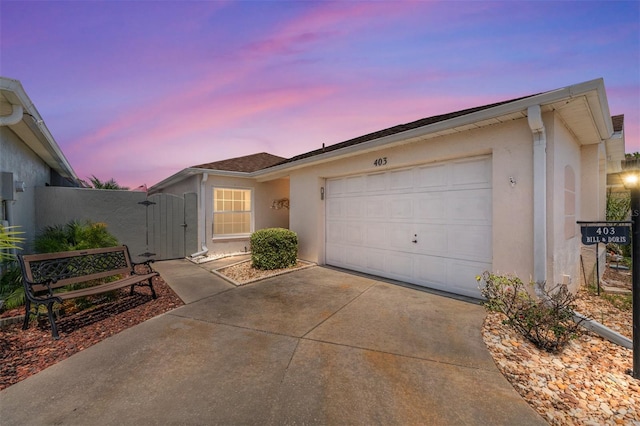 403 Duarte Ln, The Villages, FL 32159 - ranch-style home featuring stucco siding, concrete driveway, a garage, and a gate