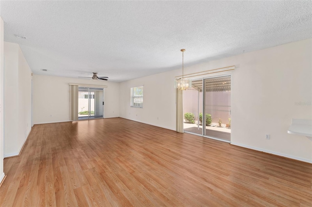 403 Duarte Ln, The Villages, FL 32159 - unfurnished living room with a chandelier, a textured ceiling, light wood-style floors, a ceiling fan, and baseboards