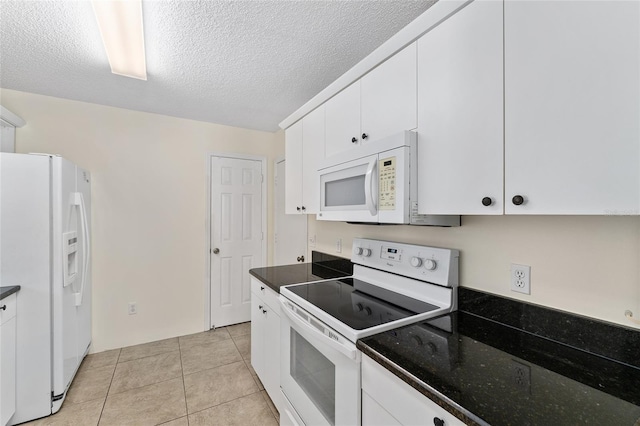 403 Duarte Ln, The Villages, FL 32159 - kitchen with white appliances, white cabinetry, a textured ceiling, light tile patterned flooring, and dark stone counters
