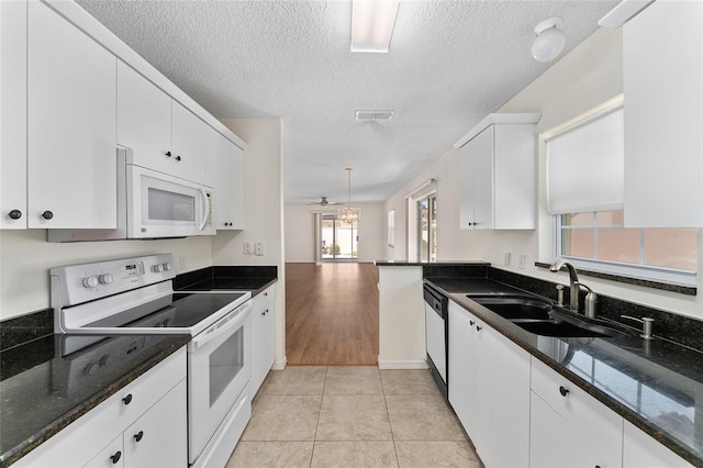 403 Duarte Ln, The Villages, FL 32159 - kitchen featuring white appliances, a sink, a textured ceiling, white cabinetry, and light tile patterned floors