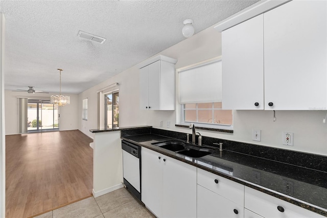 403 Duarte Ln, The Villages, FL 32159 - kitchen with dishwasher, a sink, a chandelier, white cabinetry, and a textured ceiling