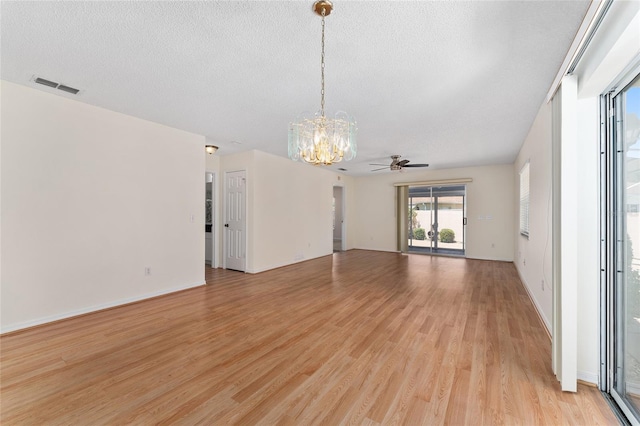 403 Duarte Ln, The Villages, FL 32159 - unfurnished room with a chandelier, a textured ceiling, light wood-style flooring, ceiling fan, and baseboards