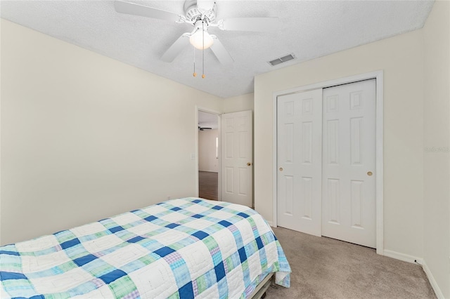 403 Duarte Ln, The Villages, FL 32159 - bedroom with light carpet, a closet, a textured ceiling, baseboards, and a ceiling fan