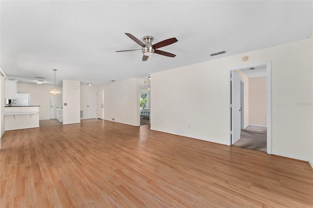 403 Duarte Ln, The Villages, FL 32159 - unfurnished living room with ceiling fan, light wood-style flooring, and a textured ceiling
