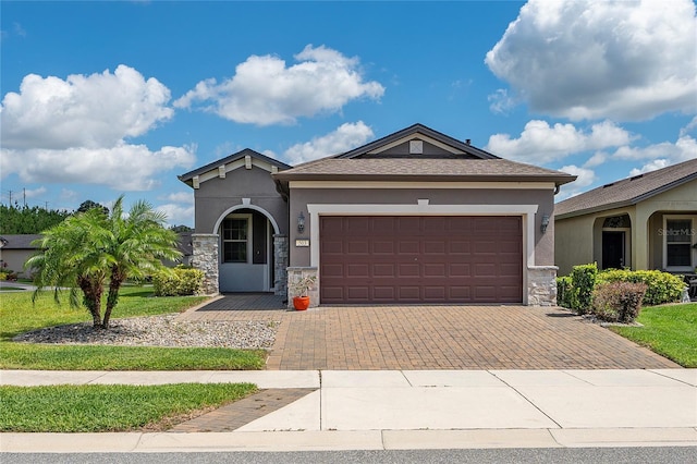 503 Vigo St, Davenport, FL 33837 - view of front of home featuring stone siding, stucco siding, decorative driveway, and a garage