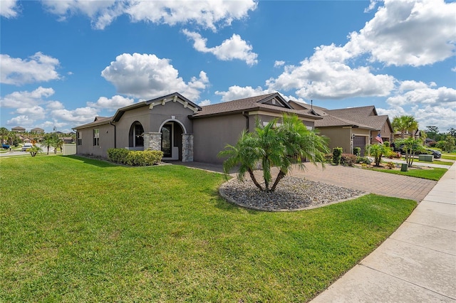 503 Vigo St, Davenport, FL 33837 - view of front facade with stucco siding, decorative driveway, a front yard, an attached garage, and stone siding