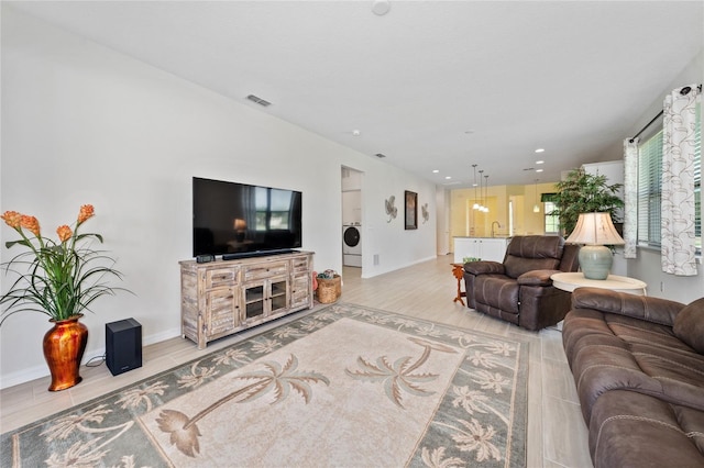 503 Vigo St, Davenport, FL 33837 - living room with washer / clothes dryer, baseboards, light wood-type flooring, and recessed lighting