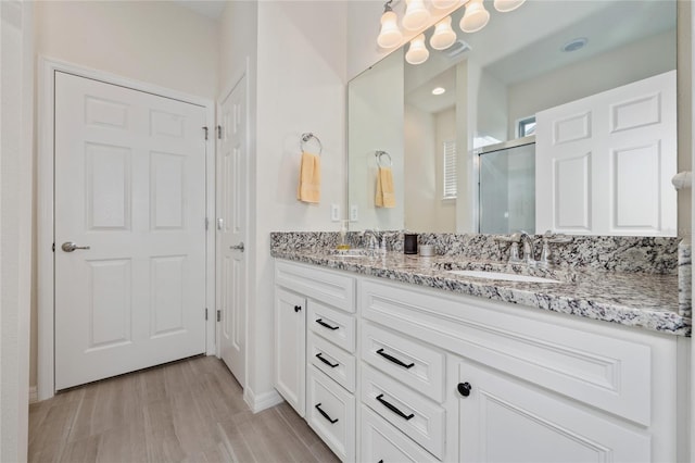 503 Vigo St, Davenport, FL 33837 - full bathroom featuring double vanity, a stall shower, wood finished floors, a chandelier, and baseboards