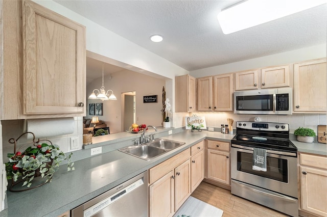 3393 Talley Ridge Dr, The Villages, FL 32162 - kitchen featuring appliances with stainless steel finishes, light brown cabinetry, a sink, a chandelier, and a textured ceiling