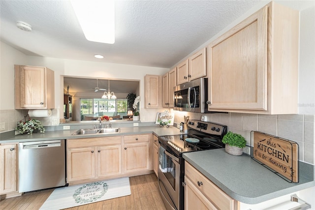 3393 Talley Ridge Dr, The Villages, FL 32162 - kitchen featuring light brown cabinetry, appliances with stainless steel finishes, a sink, decorative backsplash, and light wood-style floors