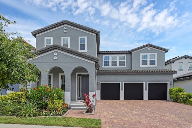 14513 Winter Stay Dr, Winter Garden, FL 34787 - view of front of house featuring an attached garage, a tiled roof, decorative driveway, and stucco siding