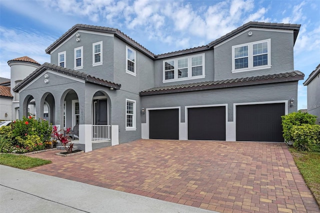 14513 Winter Stay Dr, Winter Garden, FL 34787 - mediterranean / spanish house with a garage, covered porch, decorative driveway, a tiled roof, and stucco siding