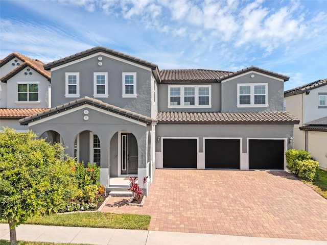 14513 Winter Stay Dr, Winter Garden, FL 34787 - view of front of property featuring covered porch, a garage, decorative driveway, and a tile roof