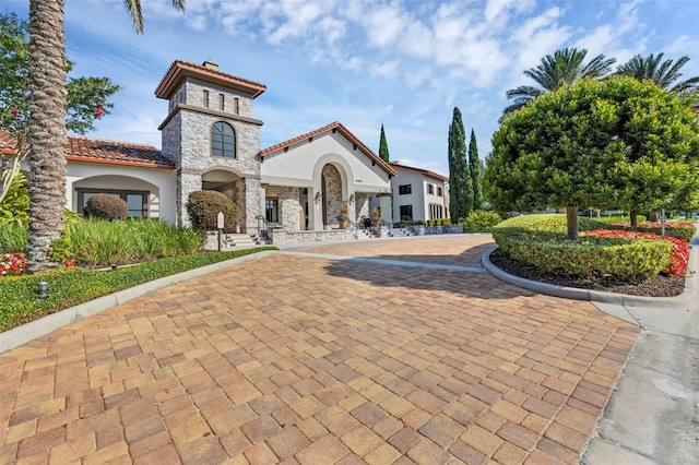 14513 Winter Stay Dr, Winter Garden, FL 34787 - mediterranean / spanish-style home featuring stone siding, stucco siding, and a tiled roof