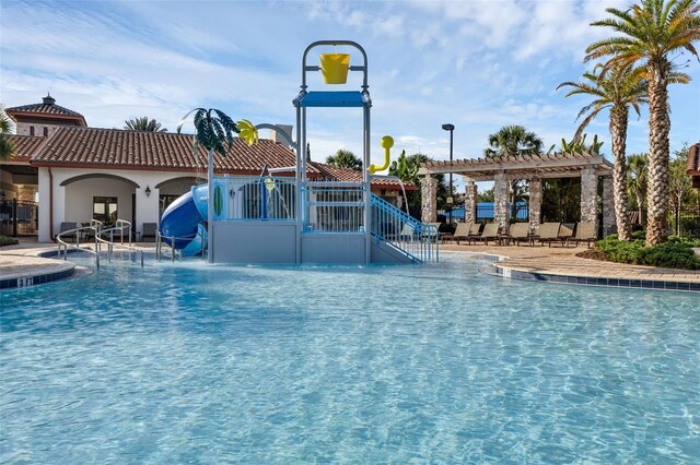 14513 Winter Stay Dr, Winter Garden, FL 34787 - community pool featuring a water slide, a pergola, and a patio area