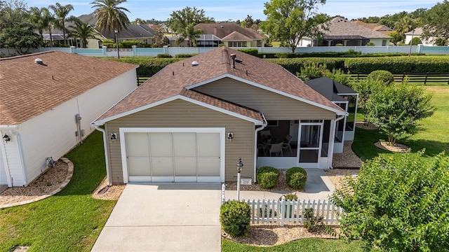 ranch-style home featuring driveway, a sunroom, and an attached garage