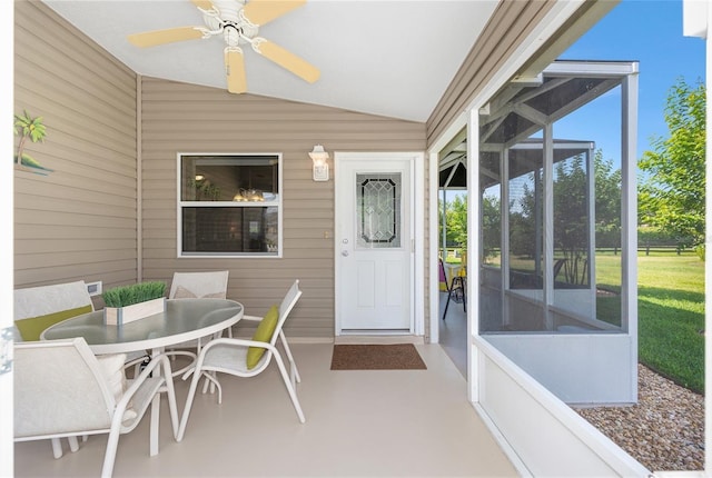 sunroom with lofted ceiling, a ceiling fan, and outdoor dining area