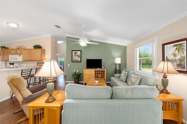 living area featuring wood finished floors, vaulted ceiling, crown molding, plenty of natural light, and a ceiling fan