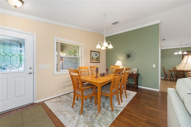 dining area with a chandelier, wood finished floors, crown molding, and baseboards
