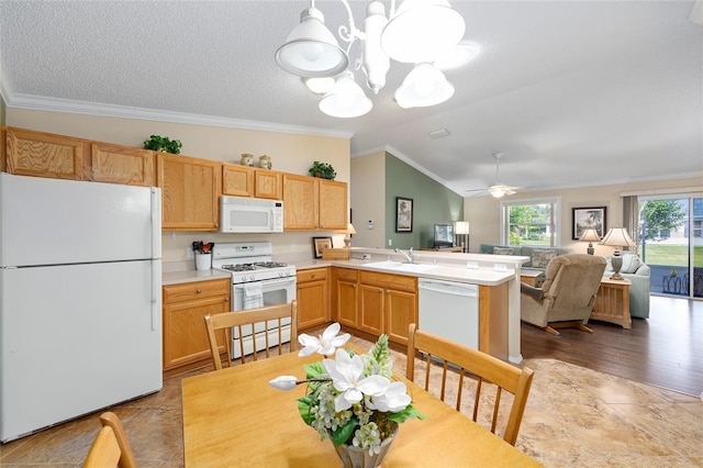 kitchen with white appliances, crown molding, a peninsula, light countertops, and lofted ceiling