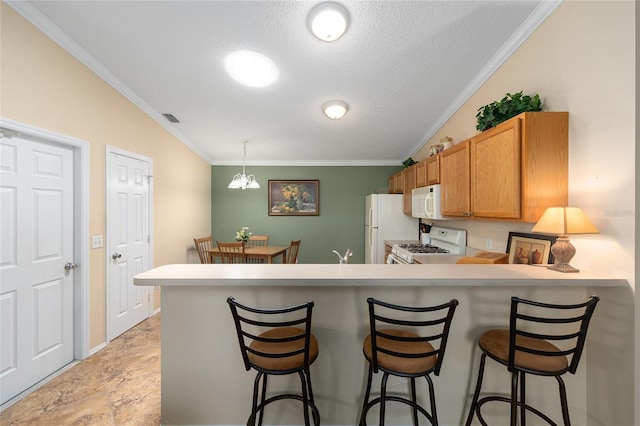 kitchen featuring white appliances, crown molding, a textured ceiling, a peninsula, and light countertops