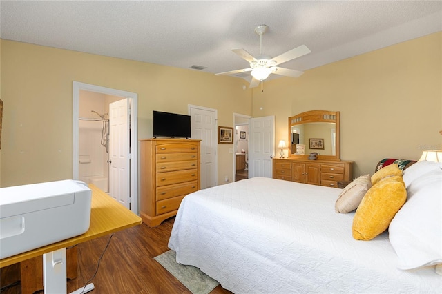 bedroom featuring wood finished floors, vaulted ceiling, connected bathroom, and a ceiling fan