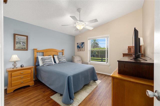 bedroom featuring lofted ceiling, wood finished floors, a ceiling fan, and baseboards